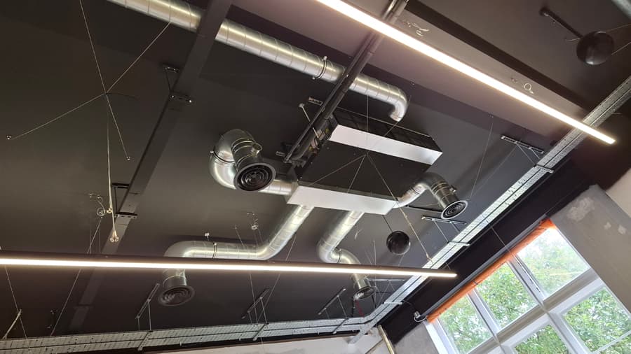 Commercial ductwork installation with black ceiling