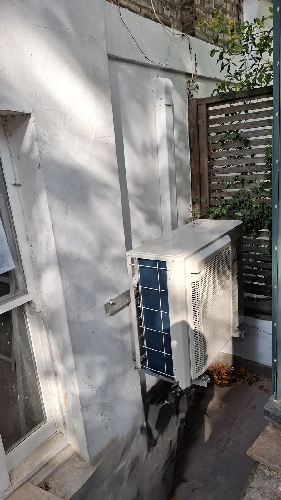 Outdoor air conditioning unit with neat trunking in courtyard
