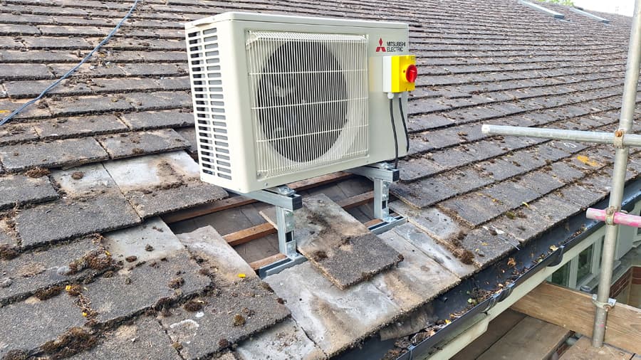 Mitsubishi outdoor unit serviced and mounted on a tiled roof