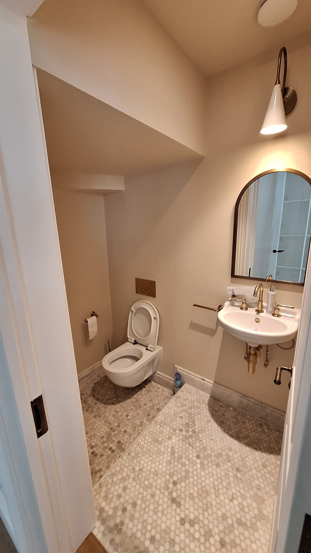 Compact cloakroom WC with wall-hung toilet and brass tap