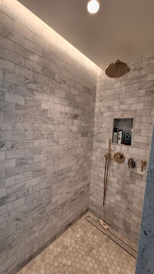 Marble walk-in shower with brass rainfall head – bathroom plumbing project by EGFF Ltd