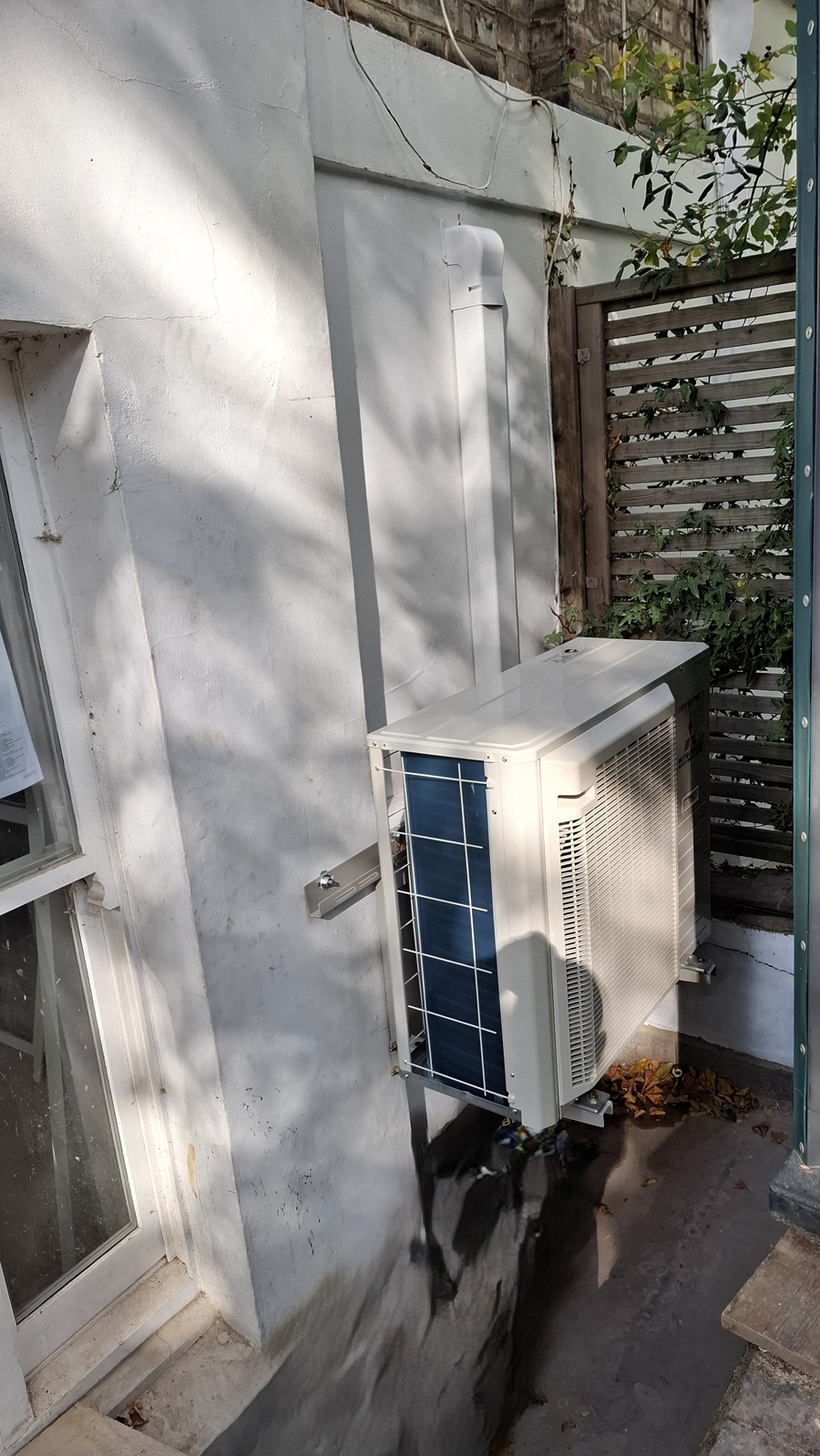 Outdoor air conditioning unit with neat trunking in courtyard